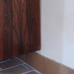 Grande enfilade vintage en palissandre de 240 cm, placage au fil en miroir, deux caissons fermant à clé de part et d'autre d'une niche centrale ouverte, tablettes intérieures en bois clair, reposant sur deux pieds pleins posés en retrait