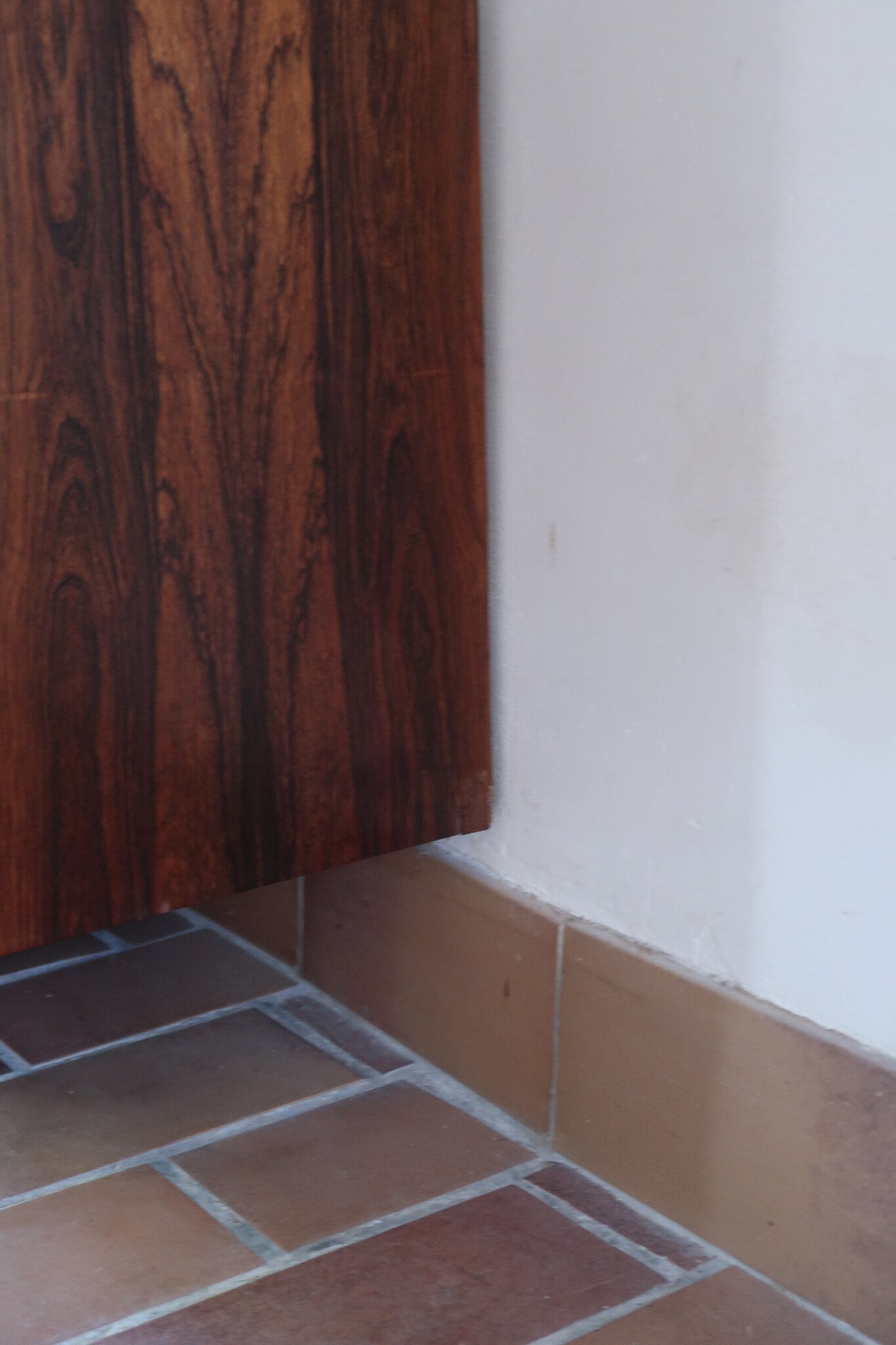 Grande enfilade vintage en palissandre de 240 cm, placage au fil en miroir, deux caissons fermant à clé de part et d'autre d'une niche centrale ouverte, tablettes intérieures en bois clair, reposant sur deux pieds pleins posés en retrait