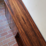 Grande enfilade vintage en palissandre de 240 cm, placage au fil en miroir, deux caissons fermant à clé de part et d'autre d'une niche centrale ouverte, tablettes intérieures en bois clair, reposant sur deux pieds pleins posés en retrait