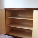 Grande enfilade vintage en palissandre de 240 cm, placage au fil en miroir, deux caissons fermant à clé de part et d'autre d'une niche centrale ouverte, tablettes intérieures en bois clair, reposant sur deux pieds pleins posés en retrait