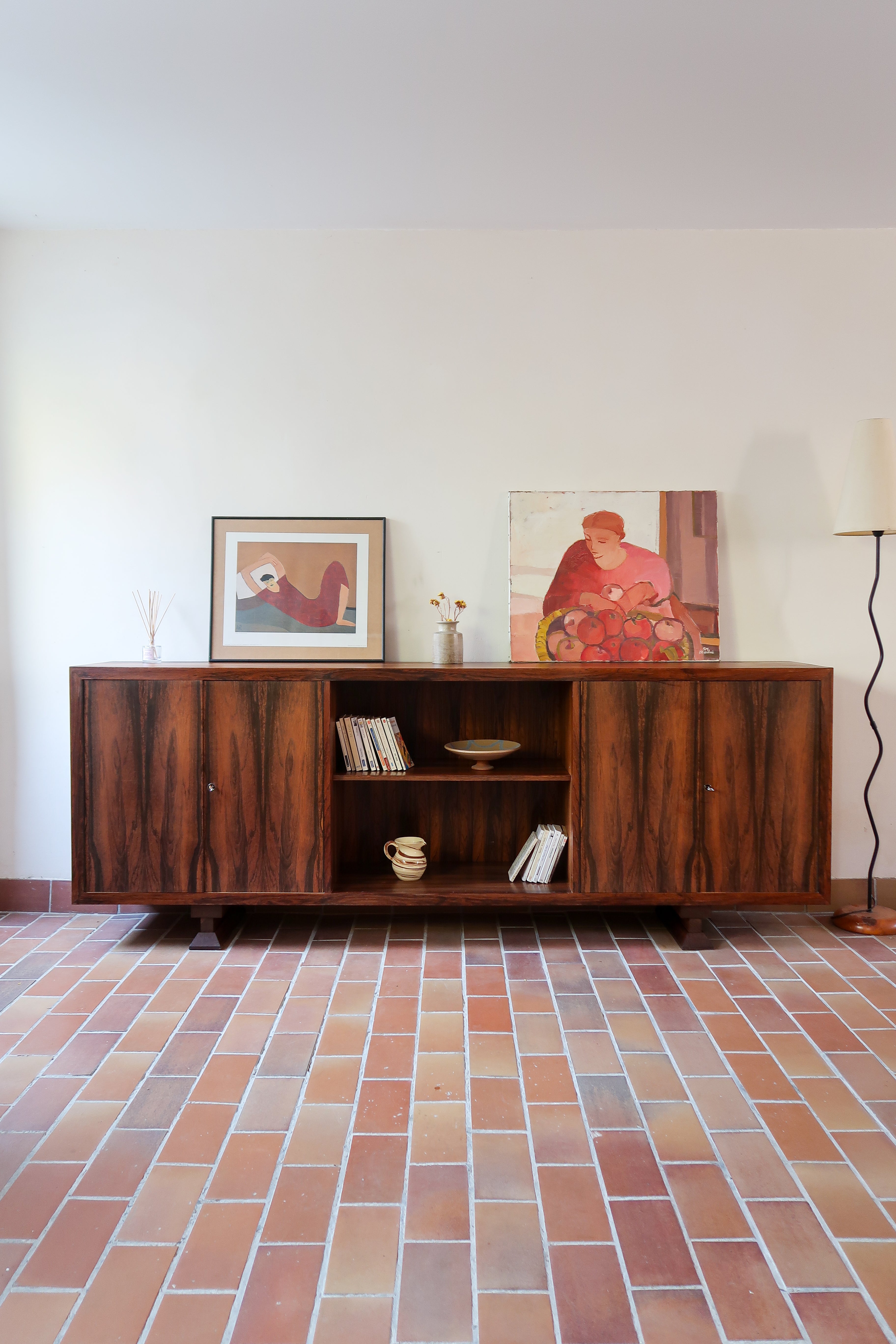 Grande enfilade vintage en palissandre de 240 cm, placage au fil en miroir, deux caissons fermant à clé de part et d'autre d'une niche centrale ouverte, tablettes intérieures en bois clair, reposant sur deux pieds pleins posés en retrait