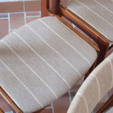 Lot de 6 chaises design danois en teck avec tissu beige rayé et dossier légèrement incurvé.