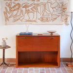 Meuble bar vintage en bois de teck, années 90, abattant sur deux compas chromés découvrant un intérieur doublé de verre noir, poignée sculptée dans la masse, niche basse ouverte sur toute la largeur