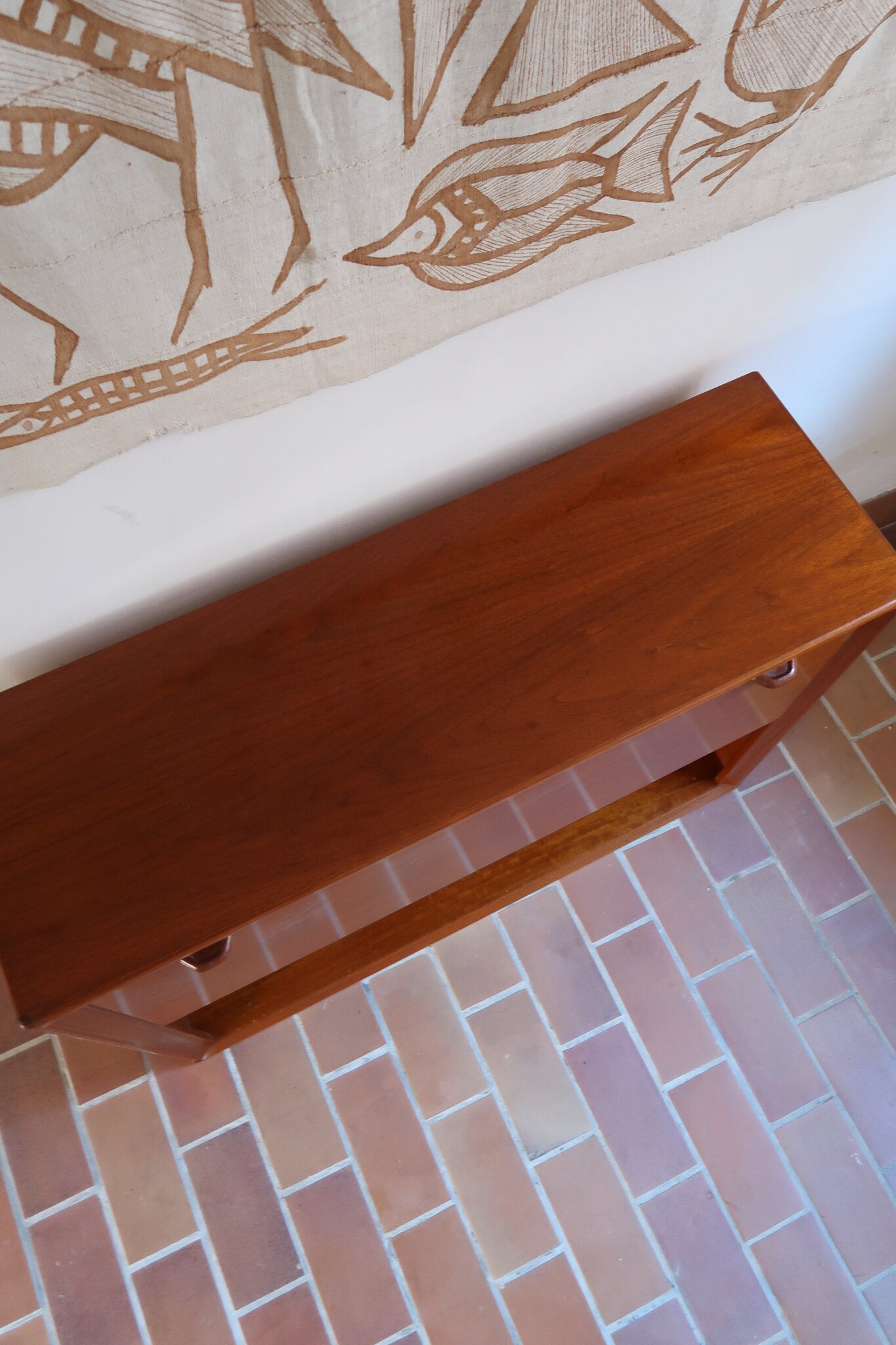 Meuble bar vintage en bois de teck, années 90, abattant sur deux compas chromés découvrant un intérieur doublé de verre noir, poignée sculptée dans la masse, niche basse ouverte sur toute la largeur