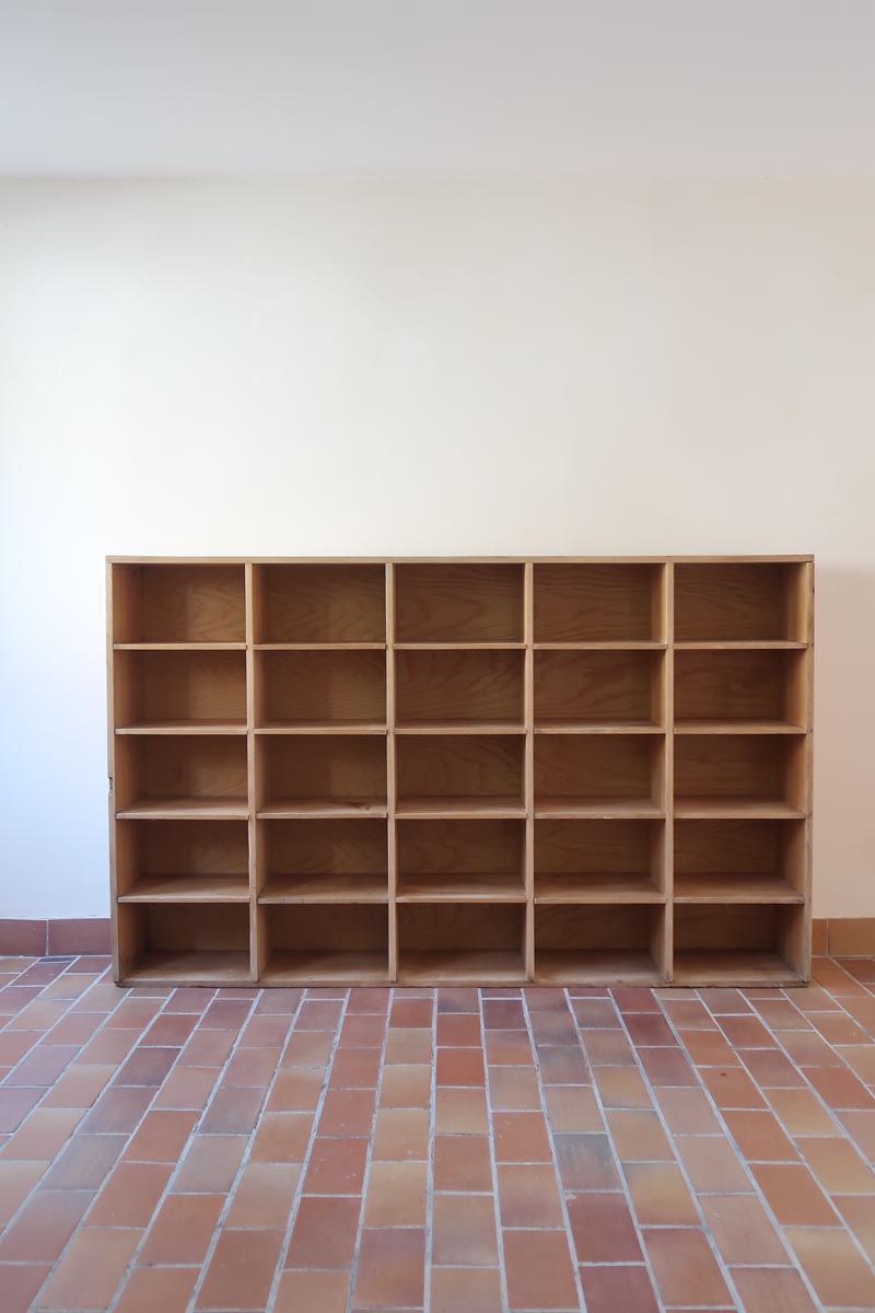 Meuble à casiers vintage en bois clair, style atelier industriel, avec 20 compartiments ouverts pour rangement de livres, vinyles ou objets décoratifs, présenté seul et en mise en situation.