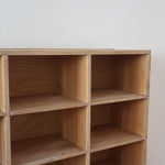 Meuble à casiers vintage en bois clair, style atelier industriel, avec 20 compartiments ouverts pour rangement de livres, vinyles ou objets décoratifs, présenté seul et en mise en situation.