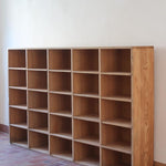 Meuble à casiers vintage en bois clair, style atelier industriel, avec 20 compartiments ouverts pour rangement de livres, vinyles ou objets décoratifs, présenté seul et en mise en situation.