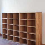 Meuble à casiers vintage en bois clair, style atelier industriel, avec 20 compartiments ouverts pour rangement de livres, vinyles ou objets décoratifs, présenté seul et en mise en situation.