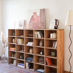 Meuble à casiers vintage en bois clair, style atelier industriel, avec 20 compartiments ouverts pour rangement de livres, vinyles ou objets décoratifs, présenté seul et en mise en situation.