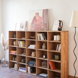 Meuble à casiers vintage en bois clair, style atelier industriel, avec 20 compartiments ouverts pour rangement de livres, vinyles ou objets décoratifs, présenté seul et en mise en situation.