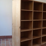 Meuble à casiers vintage en bois clair, style atelier industriel, avec 20 compartiments ouverts pour rangement de livres, vinyles ou objets décoratifs, présenté seul et en mise en situation.