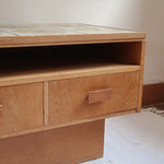 Meuble TV vintage en bois des années 70 avec plateau en céramique à motif floral, trois tiroirs et niches ouvertes.
