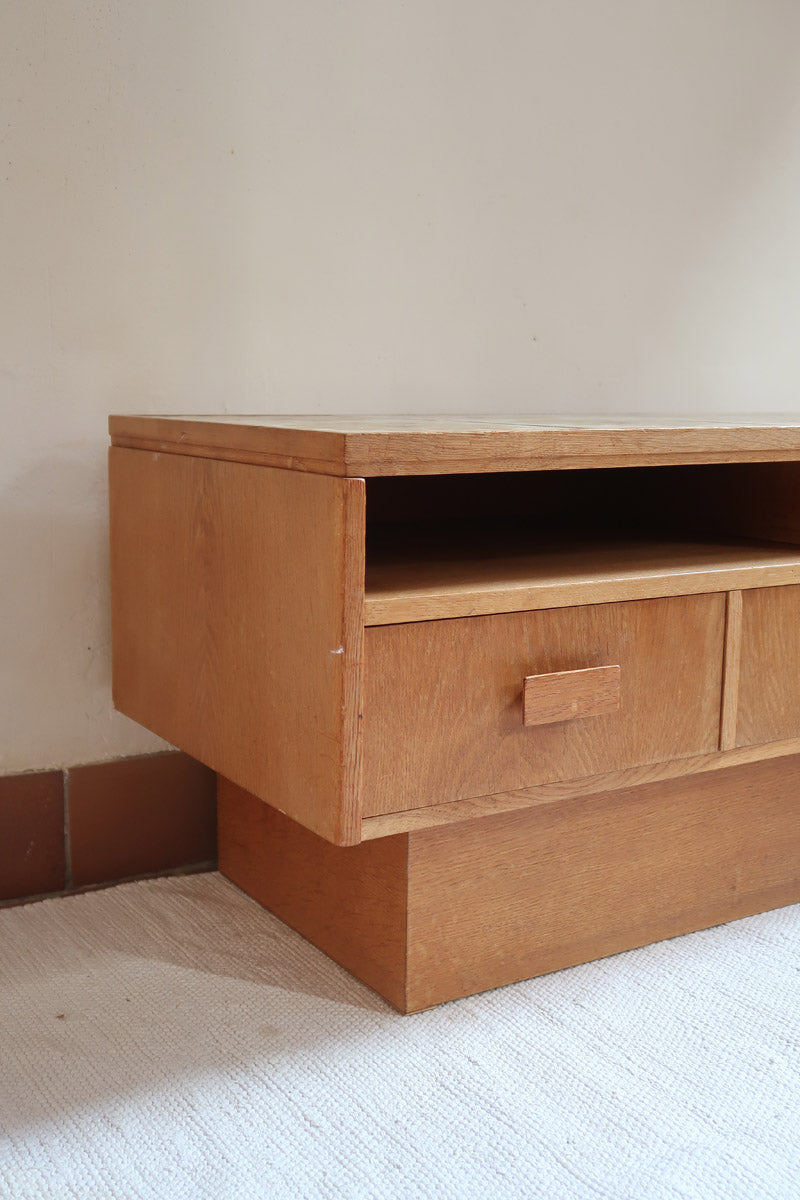 Meuble TV vintage en bois des années 70 avec plateau en céramique à motif floral, trois tiroirs et niches ouvertes.