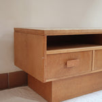 Meuble TV vintage en bois des années 70 avec plateau en céramique à motif floral, trois tiroirs et niches ouvertes.