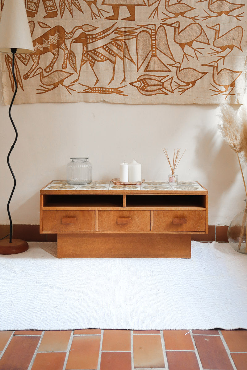 Meuble TV vintage en bois des années 70 avec plateau en céramique à motif floral, trois tiroirs et niches ouvertes.