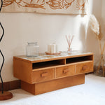 Meuble TV vintage en bois des années 70 avec plateau en céramique à motif floral, trois tiroirs et niches ouvertes.