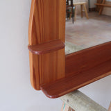 Miroir mural vintage à cadre en pin massif, montants profilés et chevilles apparentes, petite tablette intégrée en partie basse, style rustique montagne