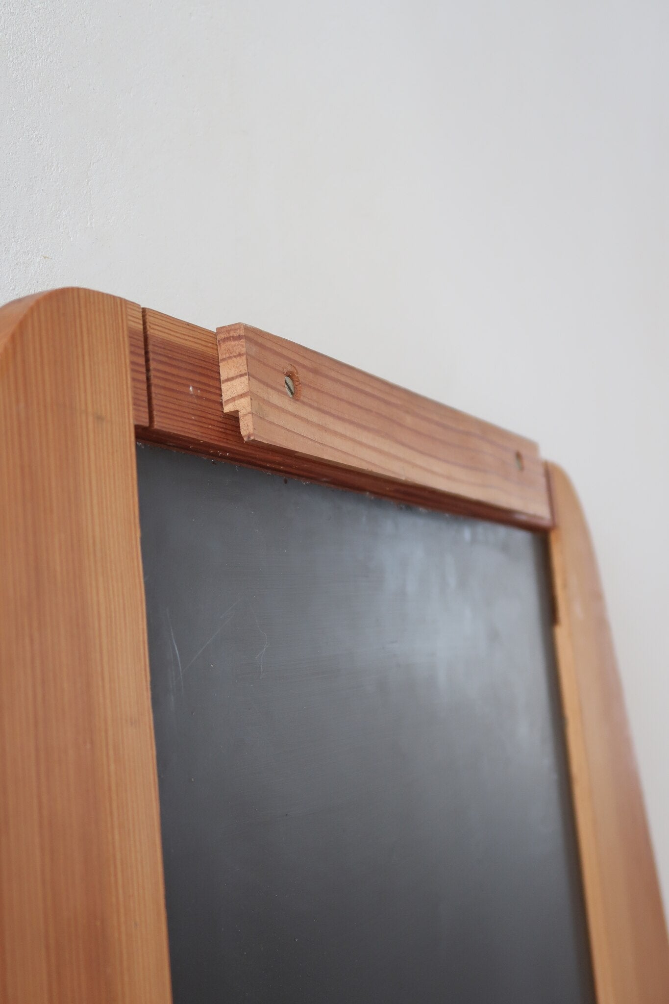 Miroir mural vintage à cadre en pin massif, montants profilés et chevilles apparentes, petite tablette intégrée en partie basse, style rustique montagne