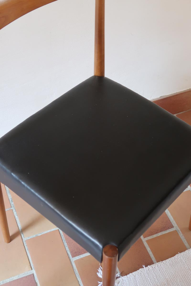 Paire de chaises scandinaves vintage en teck massif avec assise et dossier en skaï noir, design années 60, présentées seules et en mise en situation.