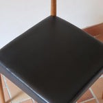 Paire de chaises scandinaves vintage en teck massif avec assise et dossier en skaï noir, design années 60, présentées seules et en mise en situation.