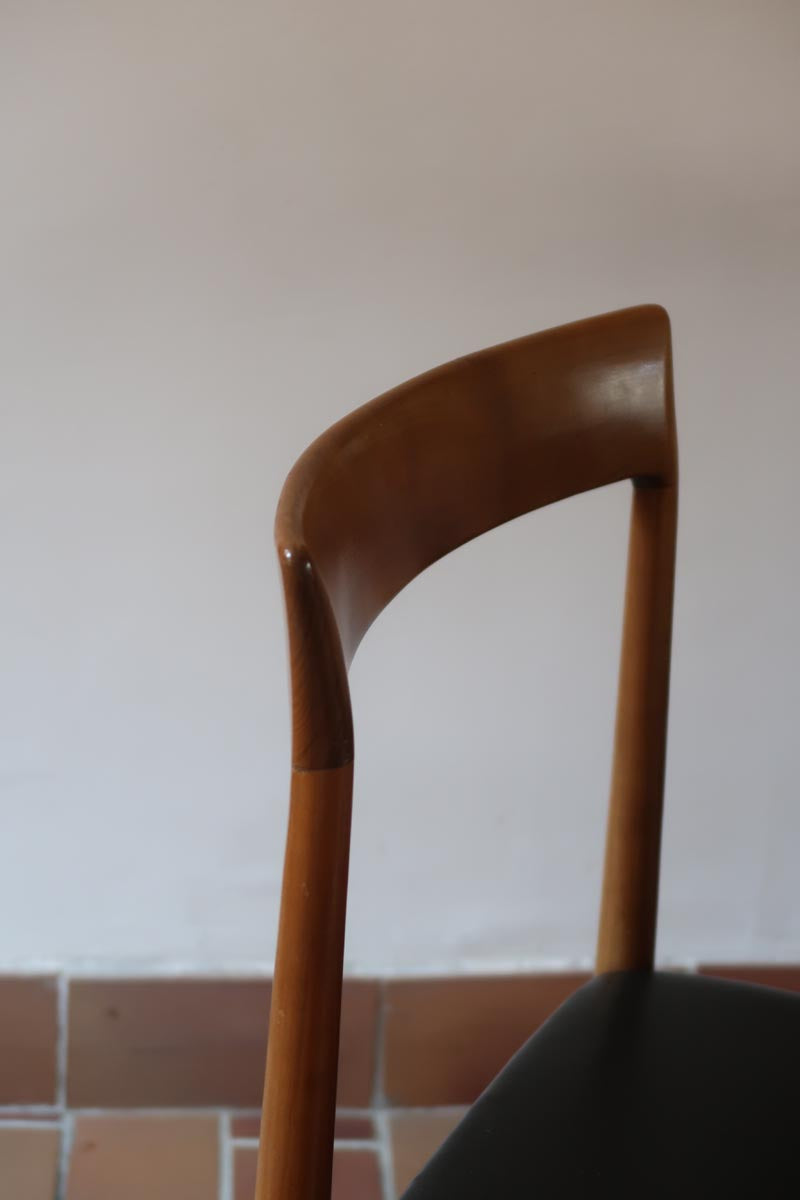 Paire de chaises scandinaves vintage en teck massif avec assise et dossier en skaï noir, design années 60, présentées seules et en mise en situation.