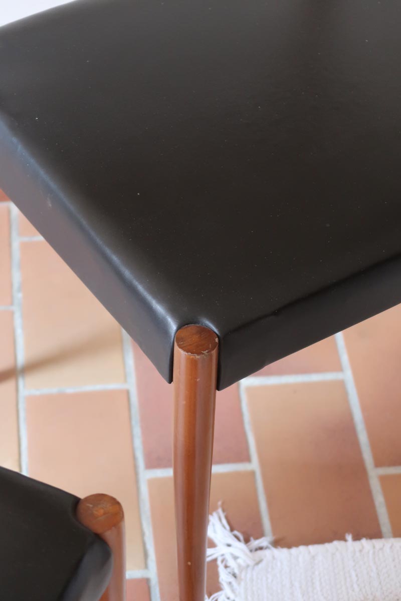 Paire de chaises scandinaves vintage en teck massif avec assise et dossier en skaï noir, design années 60, présentées seules et en mise en situation.