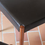 Paire de chaises scandinaves vintage en teck massif avec assise et dossier en skaï noir, design années 60, présentées seules et en mise en situation.