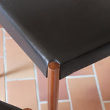 Paire de chaises scandinaves vintage en teck massif avec assise et dossier en skaï noir, design années 60, présentées seules et en mise en situation.