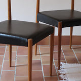 Paire de chaises scandinaves vintage en teck massif avec assise et dossier en skaï noir, design années 60, présentées seules et en mise en situation.