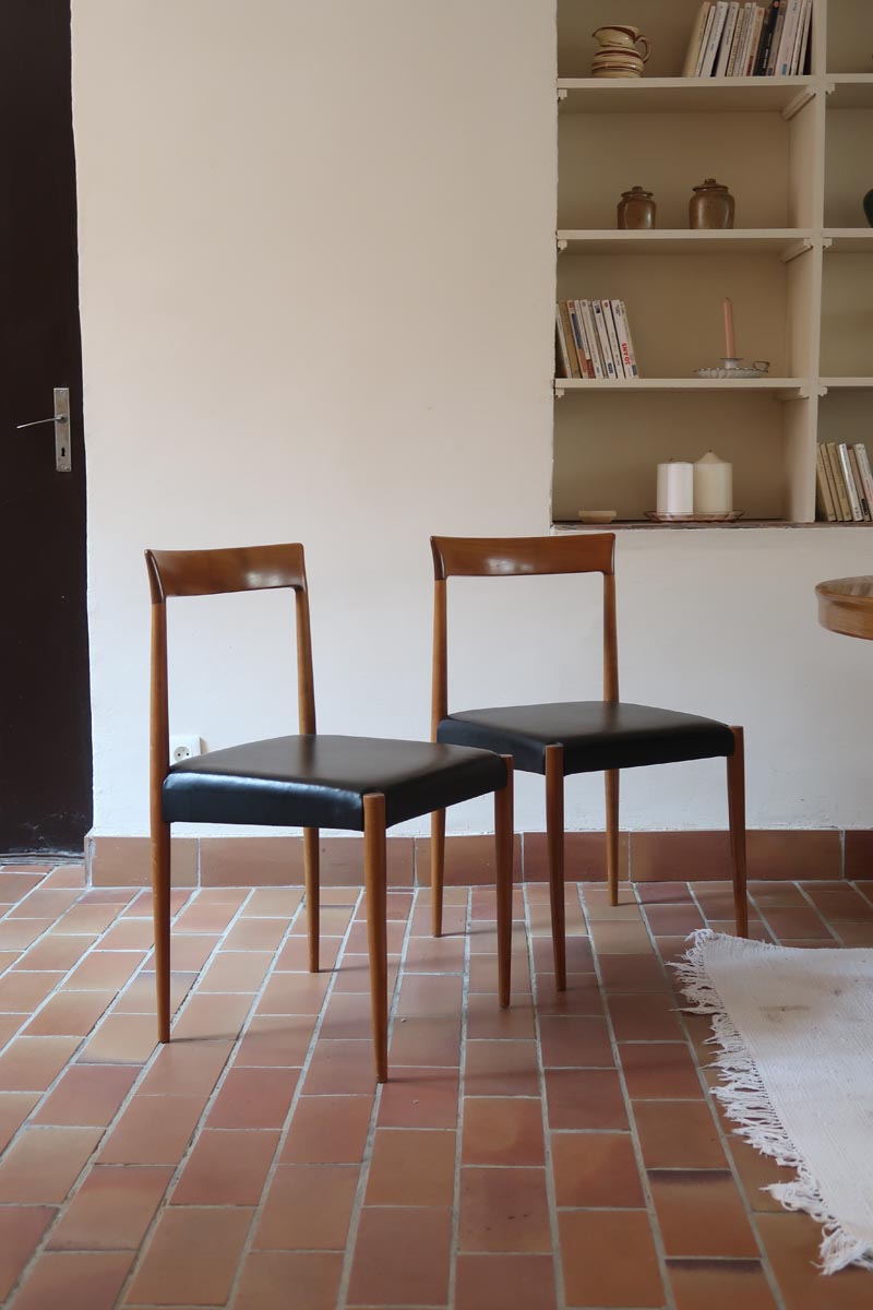 Paire de chaises scandinaves vintage en teck massif avec assise et dossier en skaï noir, design années 60, présentées seules et en mise en situation.