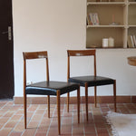 Paire de chaises scandinaves vintage en teck massif avec assise et dossier en skaï noir, design années 60, présentées seules et en mise en situation.