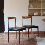 Paire de chaises scandinaves vintage en teck massif avec assise et dossier en skaï noir, design années 60, présentées seules et en mise en situation.