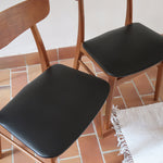 Paire de chaises scandinaves Farstrup en teck avec assise en skaï noir, design danois des années 60.
