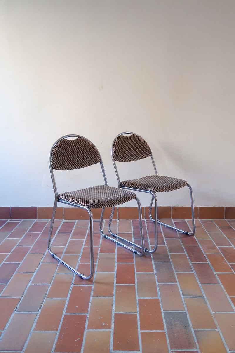 Paire de chaises vintage en chrome tubulaire avec assise et dossier en tissu à motif géométrique.
