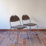 Paire de chaises vintage en chrome tubulaire avec assise et dossier en tissu à motif géométrique.
