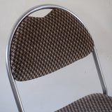 Paire de chaises vintage en chrome tubulaire avec assise et dossier en tissu à motif géométrique.

