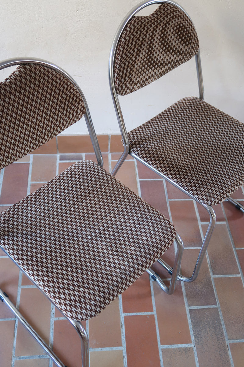 Paire de chaises vintage en chrome tubulaire avec assise et dossier en tissu à motif géométrique.
