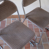 Paire de chaises vintage en chrome tubulaire avec assise et dossier en tissu à motif géométrique.
