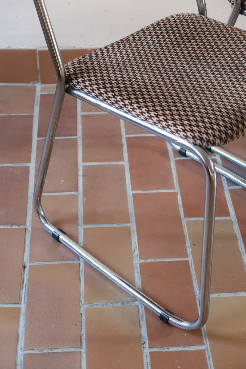 Paire de chaises vintage en chrome tubulaire avec assise et dossier en tissu à motif géométrique.

