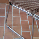 Paire de chaises vintage en chrome tubulaire avec assise et dossier en tissu à motif géométrique.
