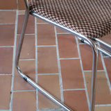 Paire de chaises vintage en chrome tubulaire avec assise et dossier en tissu à motif géométrique.

