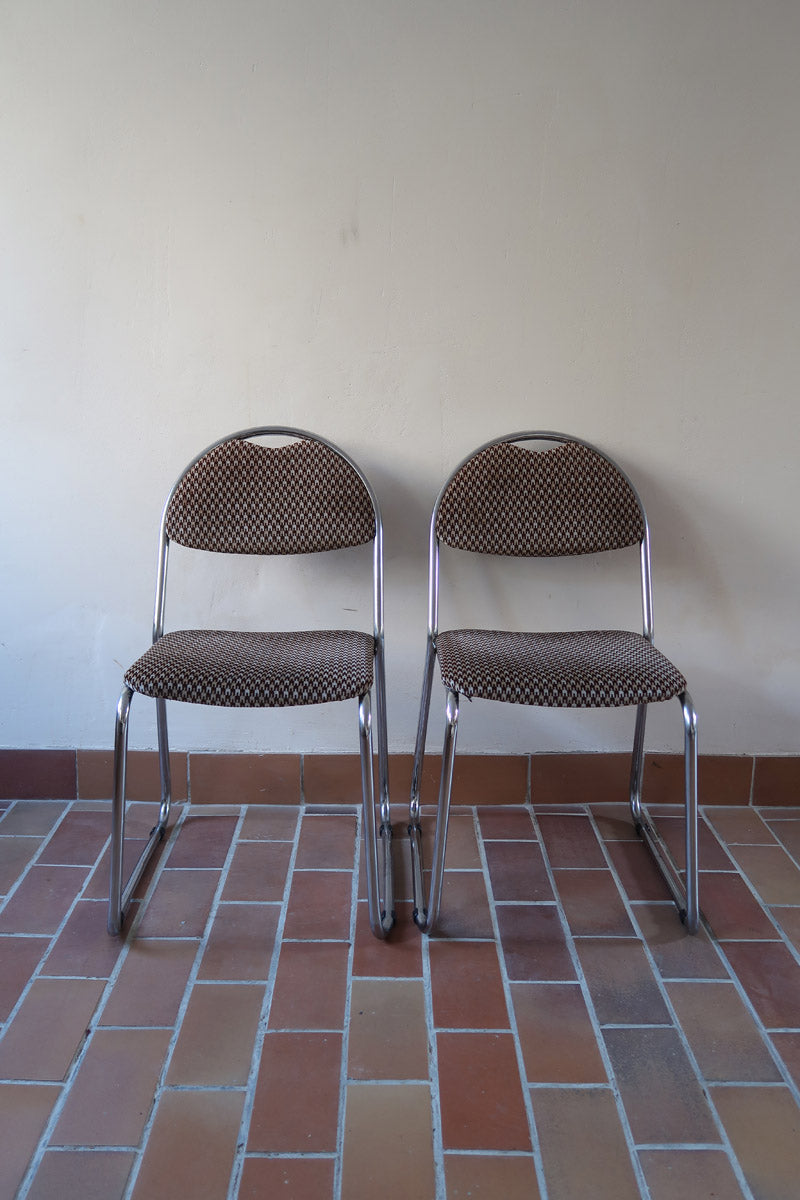 Paire de chaises vintage en chrome tubulaire avec assise et dossier en tissu à motif géométrique.
