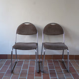 Paire de chaises vintage en chrome tubulaire avec assise et dossier en tissu à motif géométrique.
