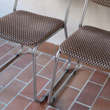 Paire de chaises vintage en chrome tubulaire avec assise et dossier en tissu à motif géométrique.
