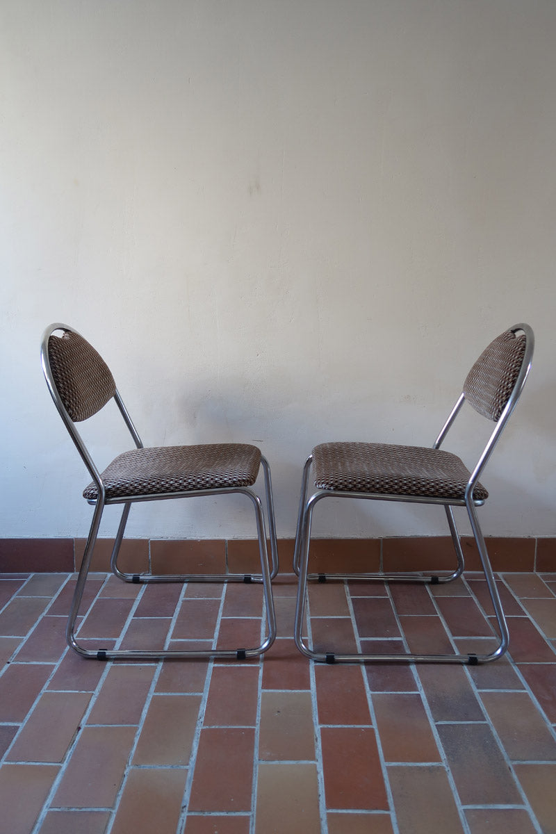 Paire de chaises vintage en chrome tubulaire avec assise et dossier en tissu à motif géométrique.
