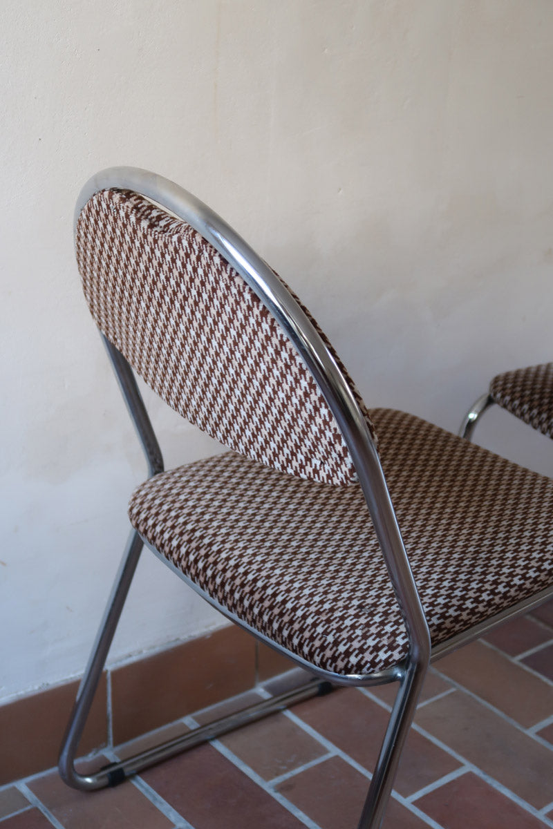 Paire de chaises vintage en chrome tubulaire avec assise et dossier en tissu à motif géométrique.

