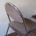 Paire de chaises vintage en chrome tubulaire avec assise et dossier en tissu à motif géométrique.
