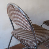 Paire de chaises vintage en chrome tubulaire avec assise et dossier en tissu à motif géométrique.
