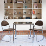 Paire de chaises vintage en chrome tubulaire avec assise et dossier en tissu à motif géométrique.
