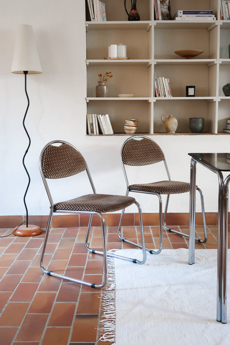 Paire de chaises vintage en chrome tubulaire avec assise et dossier en tissu à motif géométrique.
